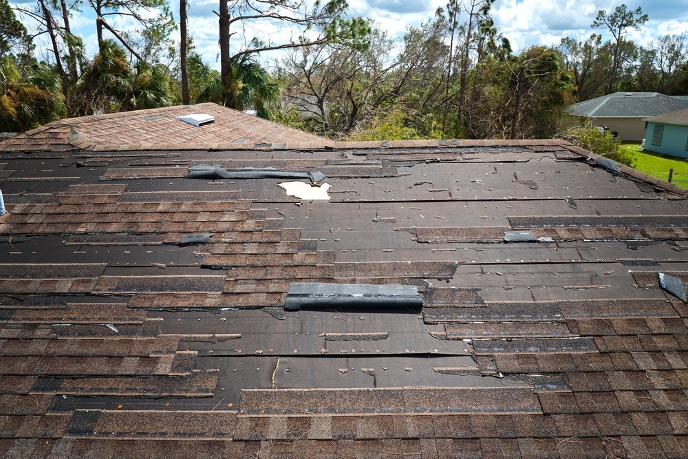 Wind,Damaged,House,Roof,With,Missing,Asphalt,Shingles,After,Hurricane